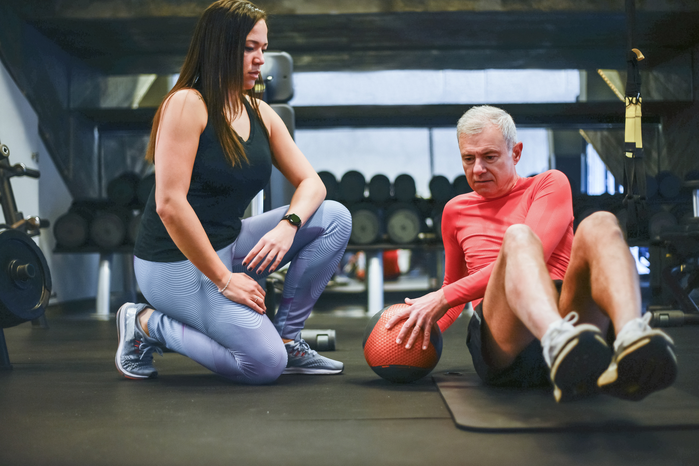 Man in Red Shirt Sitting Beside Woman in Black Tank Top and Blue Denim Jeans